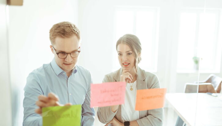 Zwei Berater brainstormen zur optimalen Unternehmensnachfolge im Mittelstand