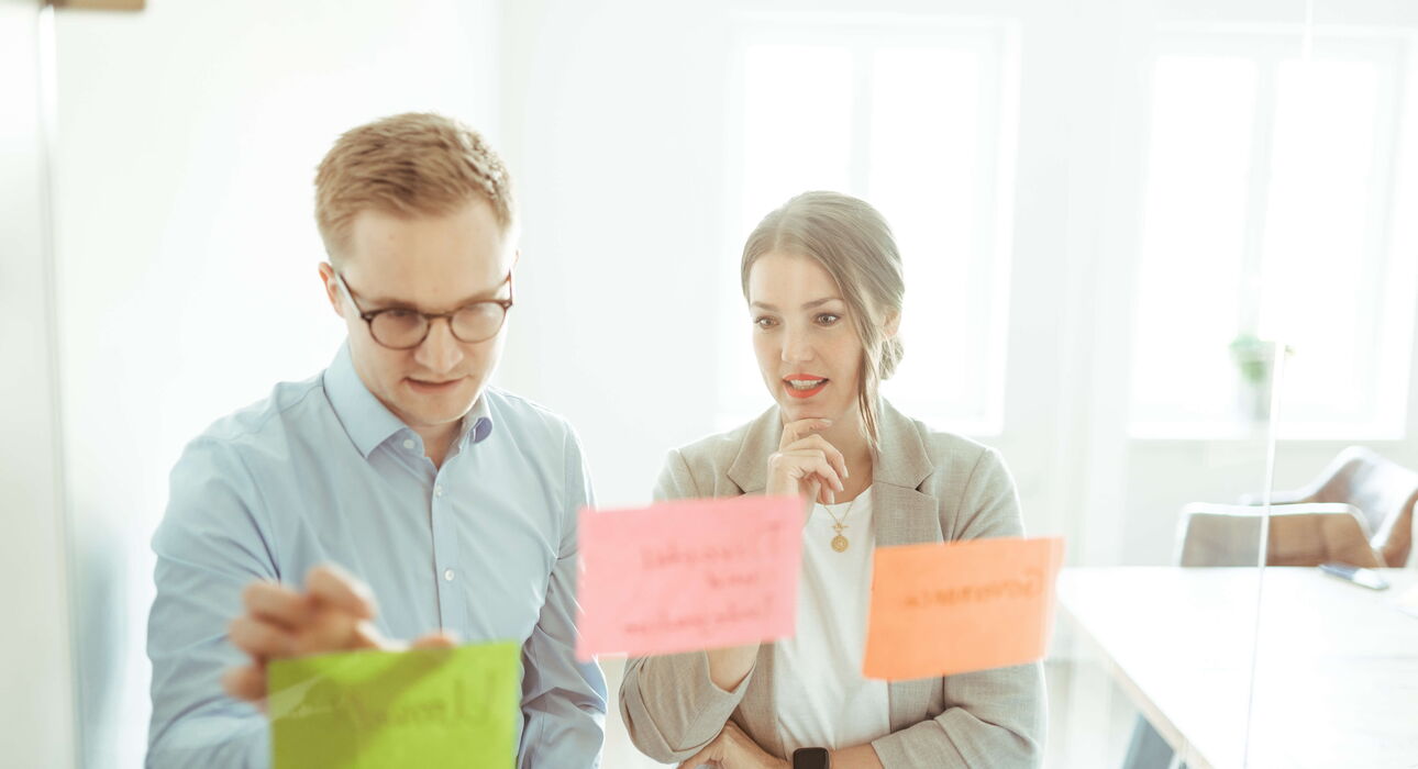 Zwei Berater brainstormen zur optimalen Unternehmensnachfolge im Mittelstand